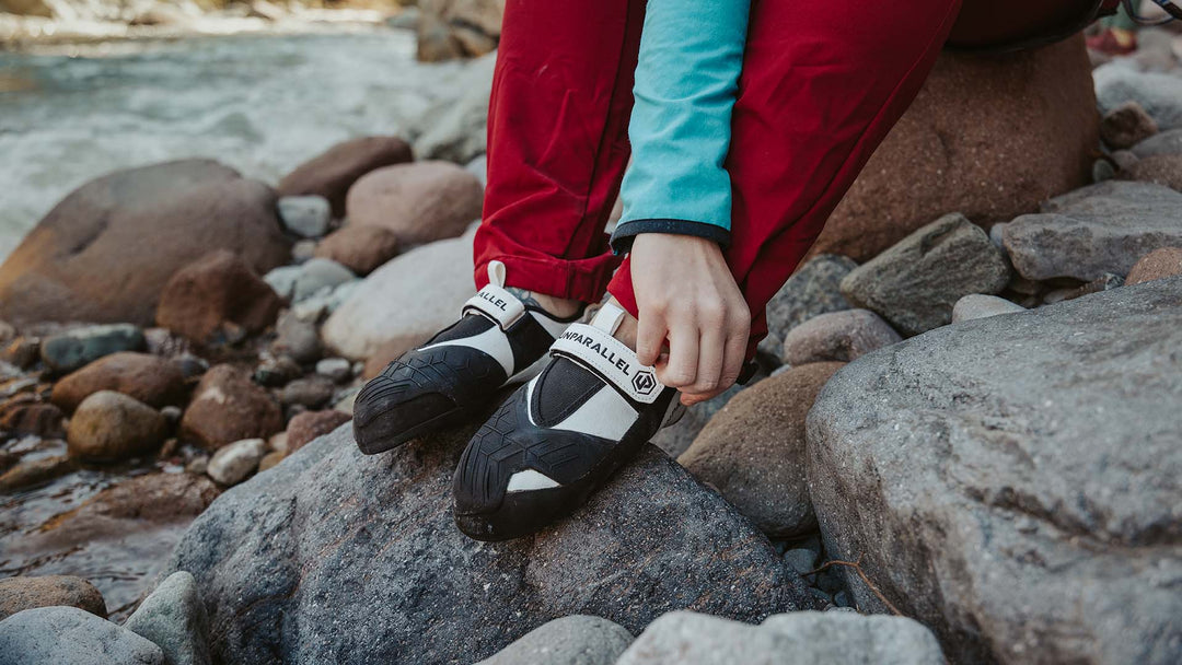 A rock climber heal hooks while wearing aggressive bouldering climbing shoes