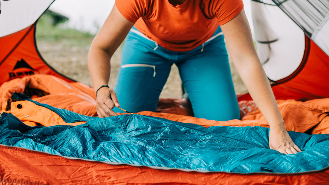 A person sets up there sleeping bag inside of a tent while backcountry camping