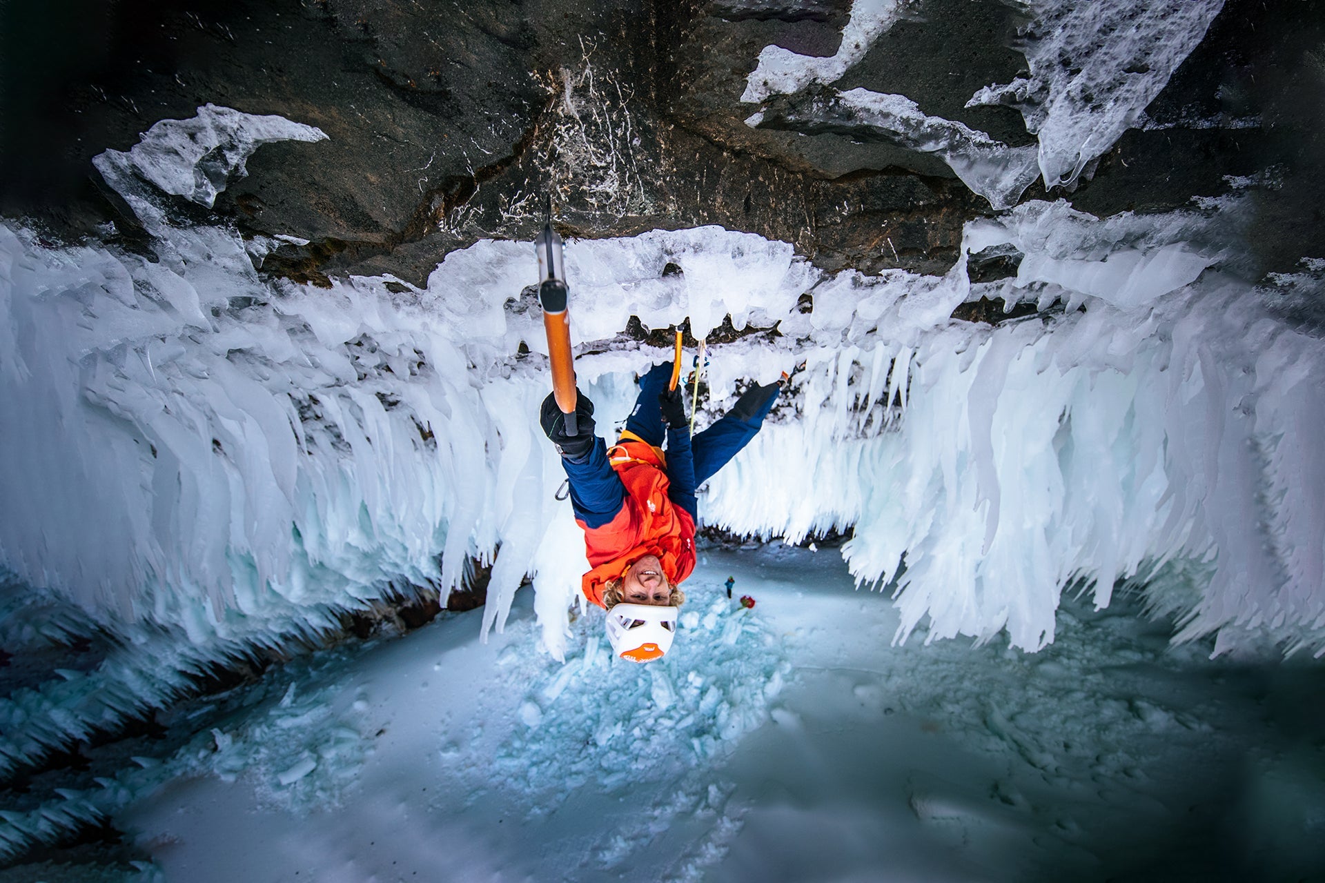 ice climber Tim Emmett dangles from an ice tool while climbing at Helmcken Falls in Western Canda