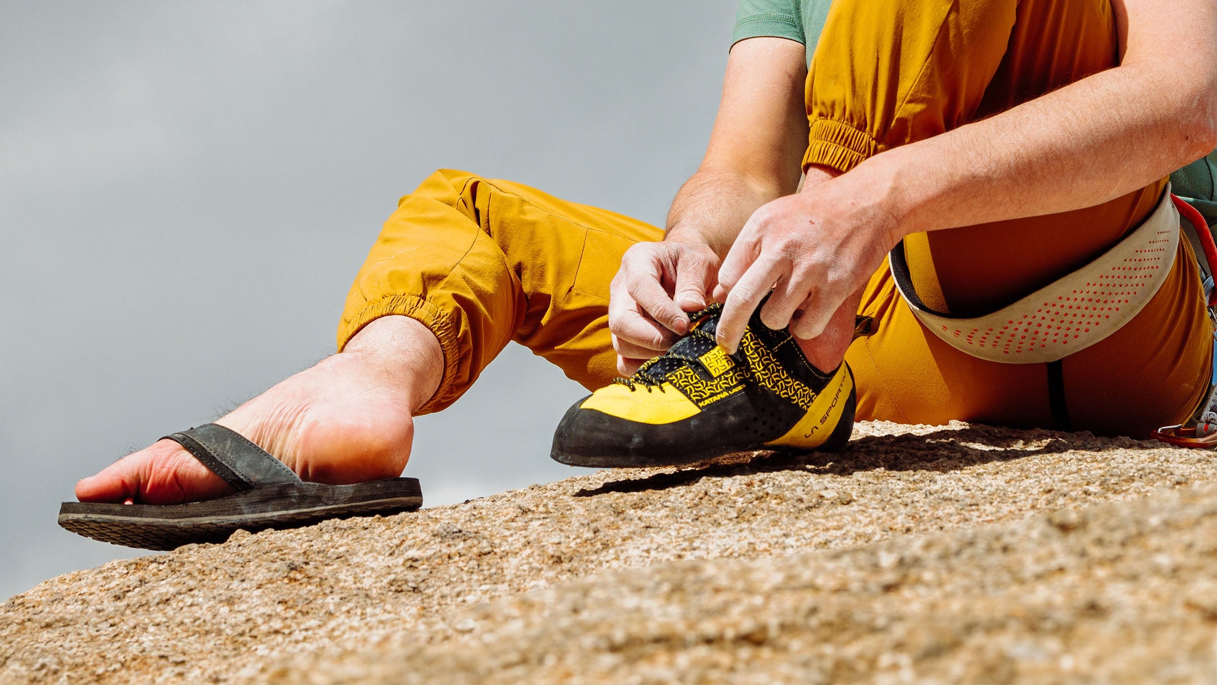 A rock climber laces up La Sportive rock climbing shoes