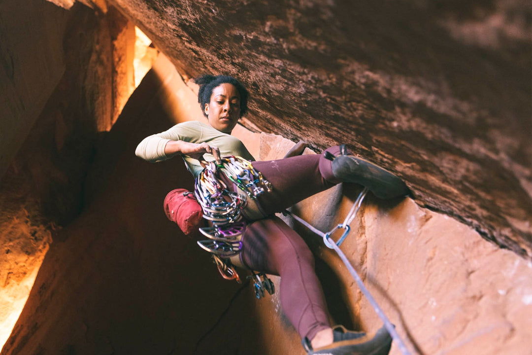 A woman rock climbs a traditional climbing route
